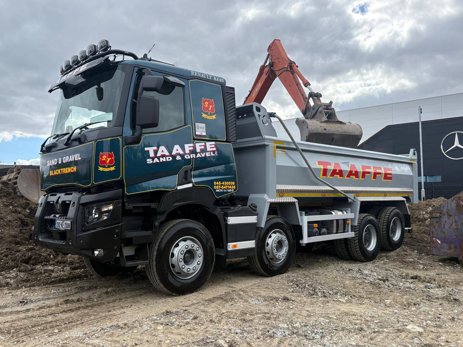 Renault K440 eight-wheel tipper being loaded by an excavator on site